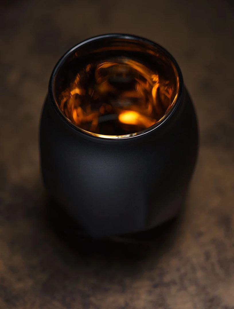 Black edition of the Norlan Whisky Glass viewed from slightly overhead with the deep golden glow of whisky inside.