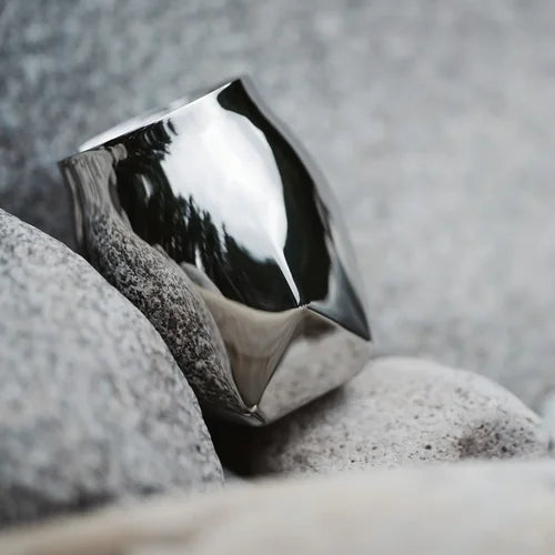 The Norlan Steel Whiskey Tumbler nestled against the side of a mountain.